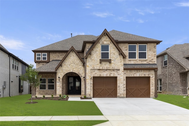 view of front of house with a garage, french doors, and a front lawn