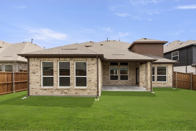 rear view of property with a patio and a lawn