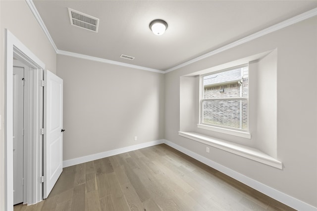 unfurnished room featuring ornamental molding and light hardwood / wood-style floors