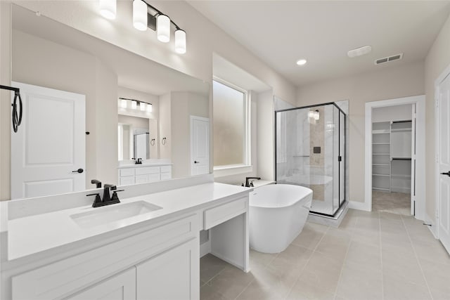 bathroom with tile patterned floors, vanity, and shower with separate bathtub