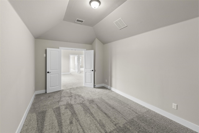 unfurnished bedroom featuring lofted ceiling and carpet