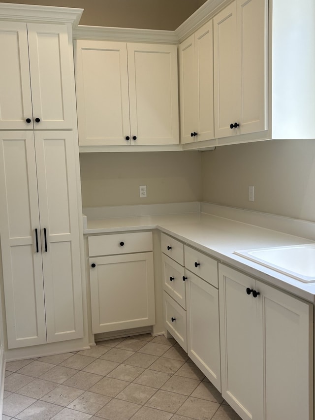 kitchen with white cabinets, light countertops, and a sink