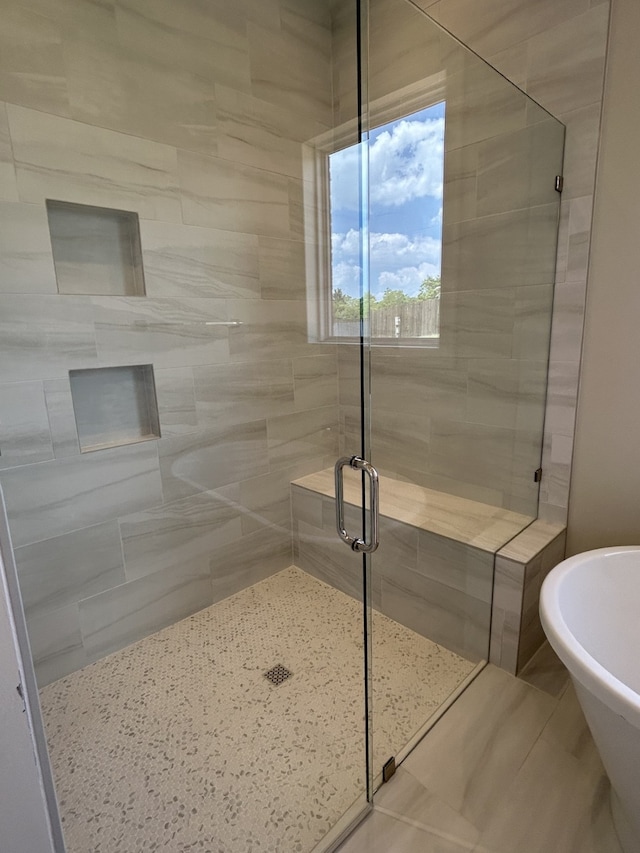 full bath with a stall shower and a freestanding bath