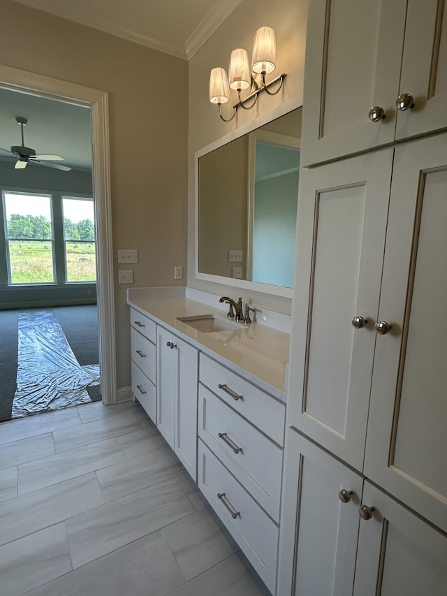 bathroom with ceiling fan, ornamental molding, and vanity