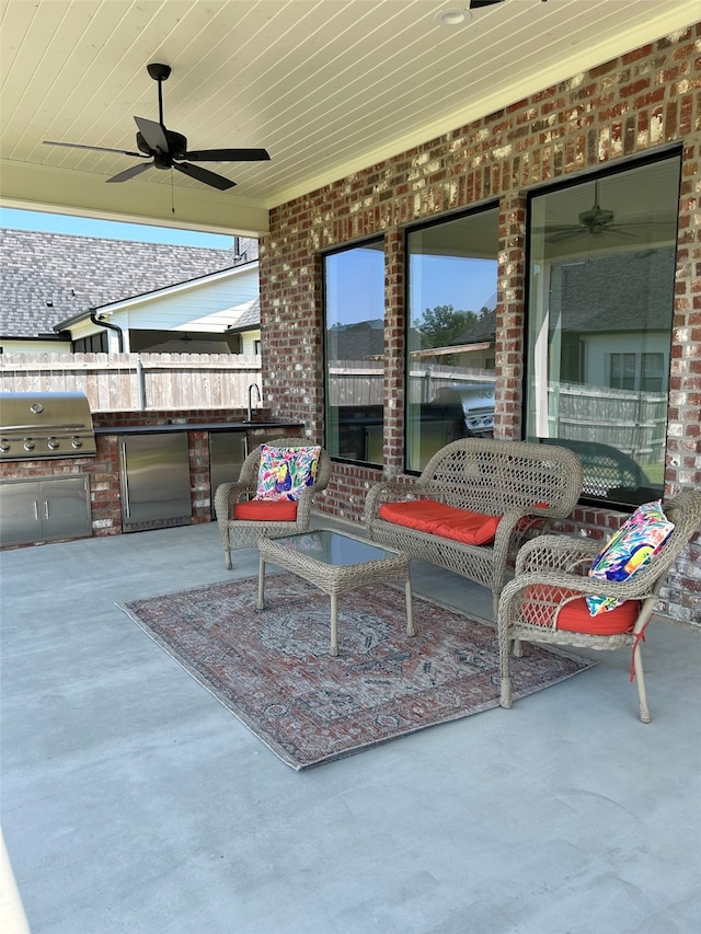 view of patio / terrace with a sink, area for grilling, ceiling fan, and fence