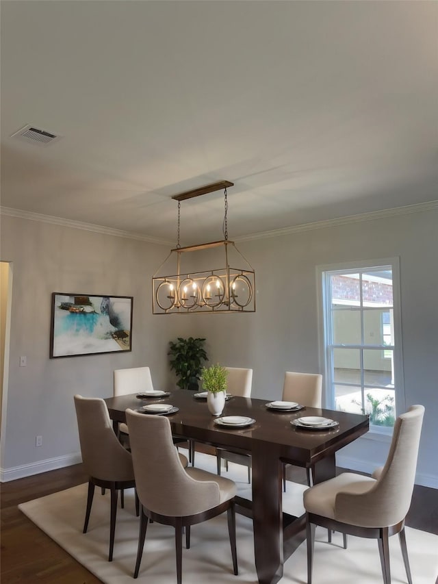 dining area with baseboards, wood finished floors, visible vents, and ornamental molding