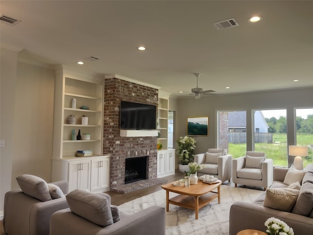 living room featuring light wood-type flooring, visible vents, a brick fireplace, and recessed lighting