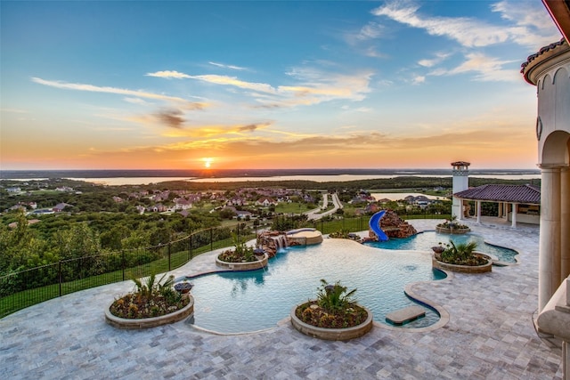 pool at dusk featuring a patio area