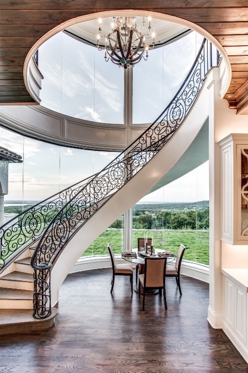 interior space with a towering ceiling, a notable chandelier, and dark hardwood / wood-style floors