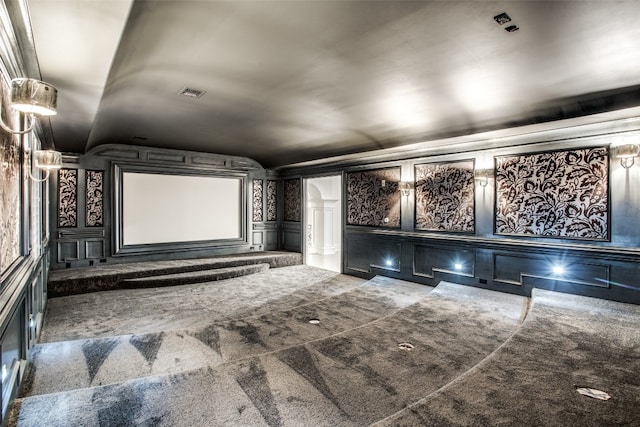 home theater with dark colored carpet and vaulted ceiling