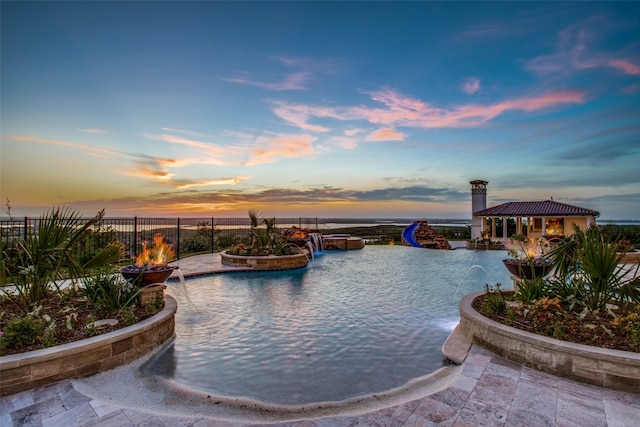 pool at dusk featuring a gazebo