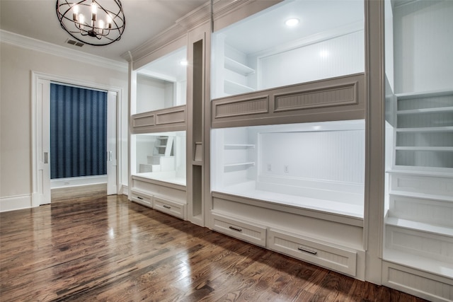 interior space with a chandelier, dark hardwood / wood-style floors, crown molding, and built in shelves