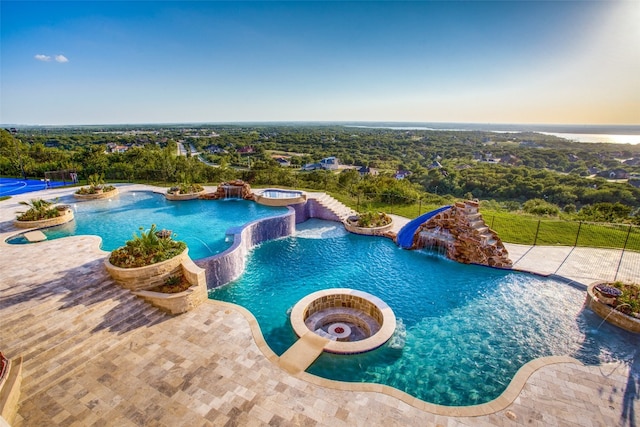 view of pool with an in ground hot tub, pool water feature, and a patio