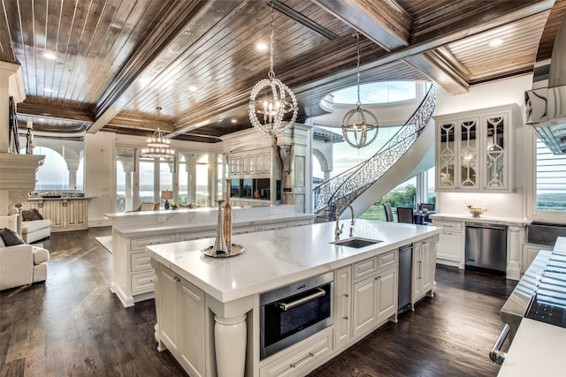 kitchen featuring an inviting chandelier, dark wood-type flooring, decorative light fixtures, wood ceiling, and a center island with sink