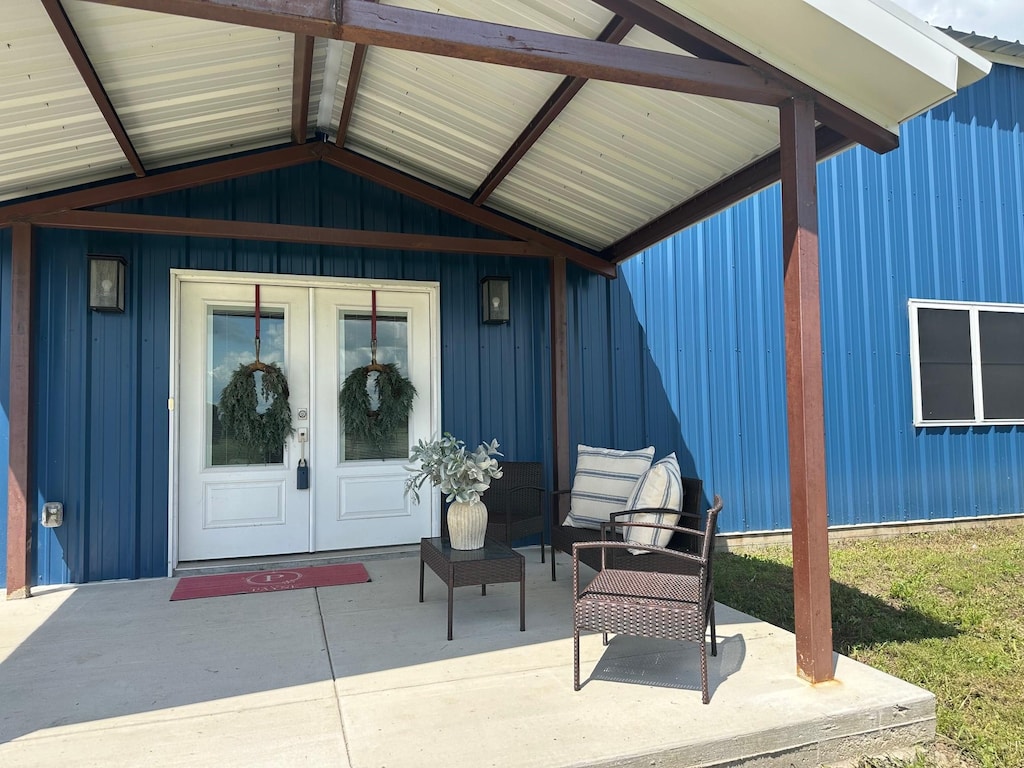 915 Ole Ambrose Rd, Bells, TX 75414 - entrance to property featuring french doors, a patio, and board and batten siding
