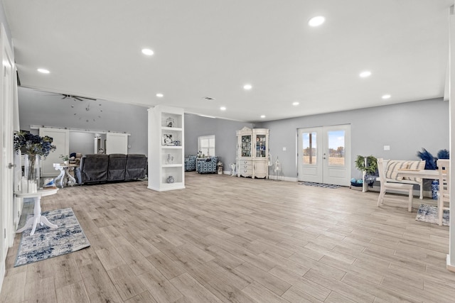 living room with ceiling fan, light hardwood / wood-style flooring, and french doors