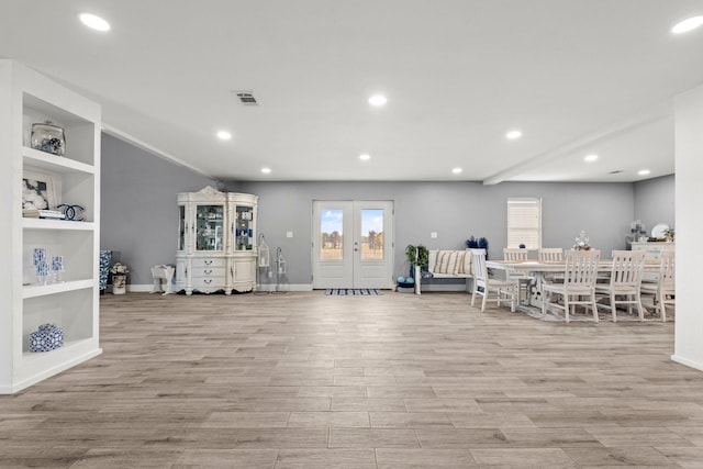 interior space with built in shelves, light hardwood / wood-style floors, and french doors