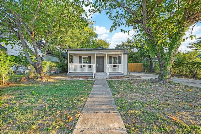 bungalow-style home featuring covered porch and a front yard