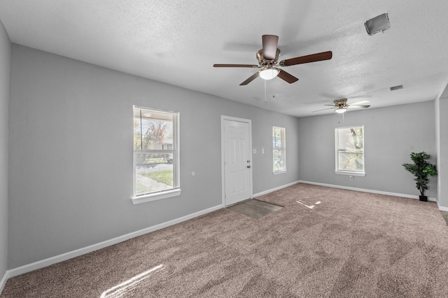 carpeted empty room with ceiling fan and a textured ceiling