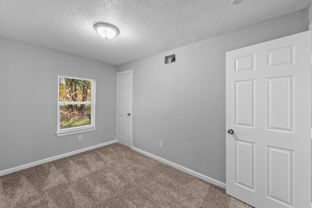 unfurnished room featuring a textured ceiling and carpet flooring