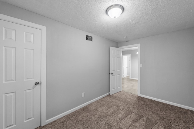 unfurnished bedroom with a textured ceiling and carpet flooring