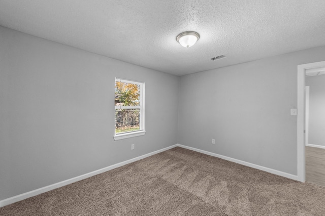 empty room featuring a textured ceiling and carpet flooring