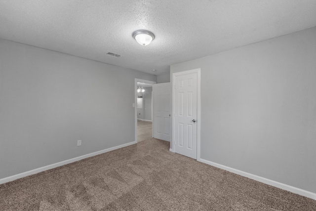 unfurnished room featuring carpet floors and a textured ceiling