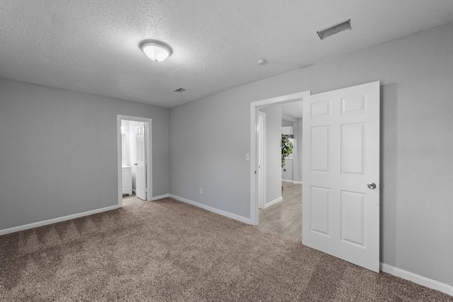 carpeted spare room featuring a textured ceiling