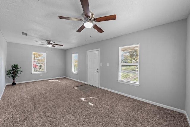 spare room featuring carpet floors, a textured ceiling, and ceiling fan