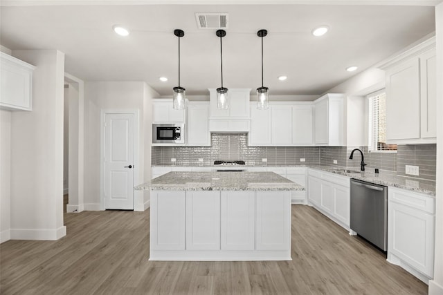 kitchen with white cabinetry, light hardwood / wood-style floors, stainless steel appliances, and decorative light fixtures