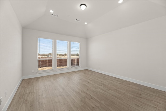 empty room with light hardwood / wood-style floors and lofted ceiling