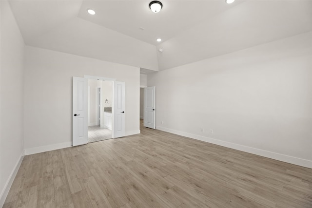 unfurnished bedroom featuring high vaulted ceiling and light hardwood / wood-style flooring