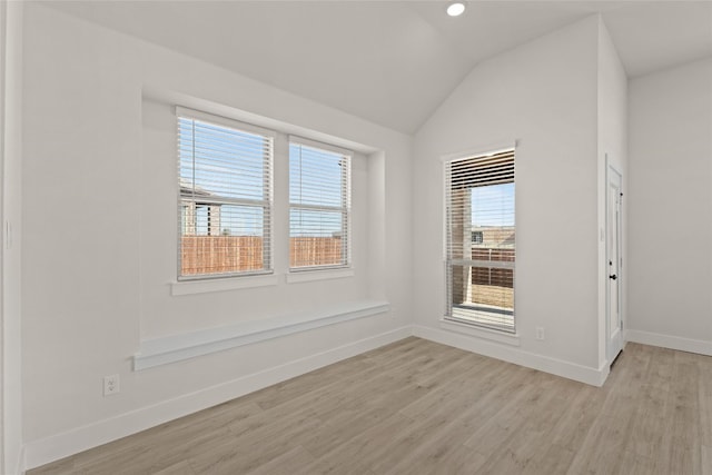 empty room featuring lofted ceiling and light wood-type flooring