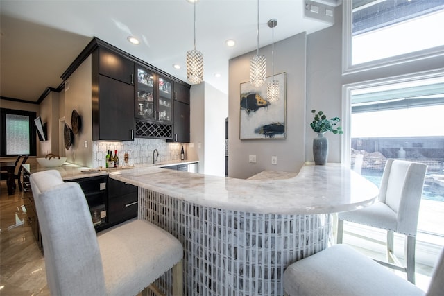 bar with tasteful backsplash, sink, and hanging light fixtures