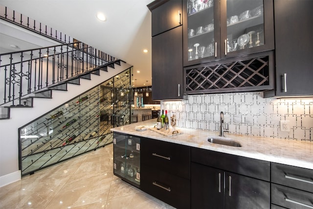 bar with light stone countertops, sink, and decorative backsplash