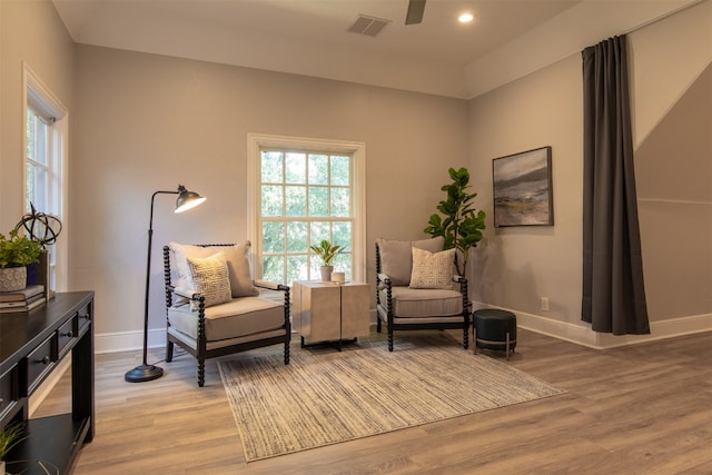 living area featuring hardwood / wood-style floors and ceiling fan