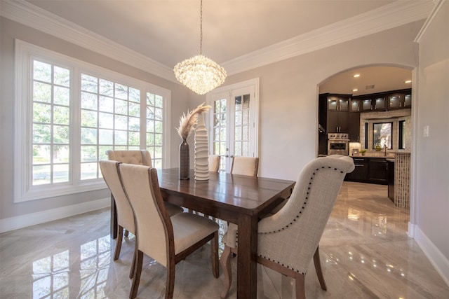 dining room featuring crown molding, sink, french doors, and a notable chandelier