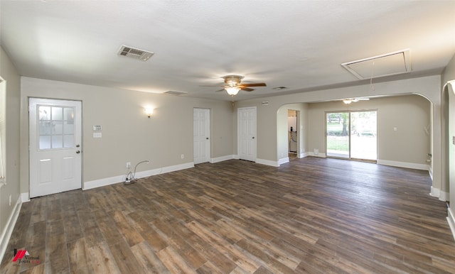 unfurnished living room featuring ceiling fan and dark hardwood / wood-style flooring