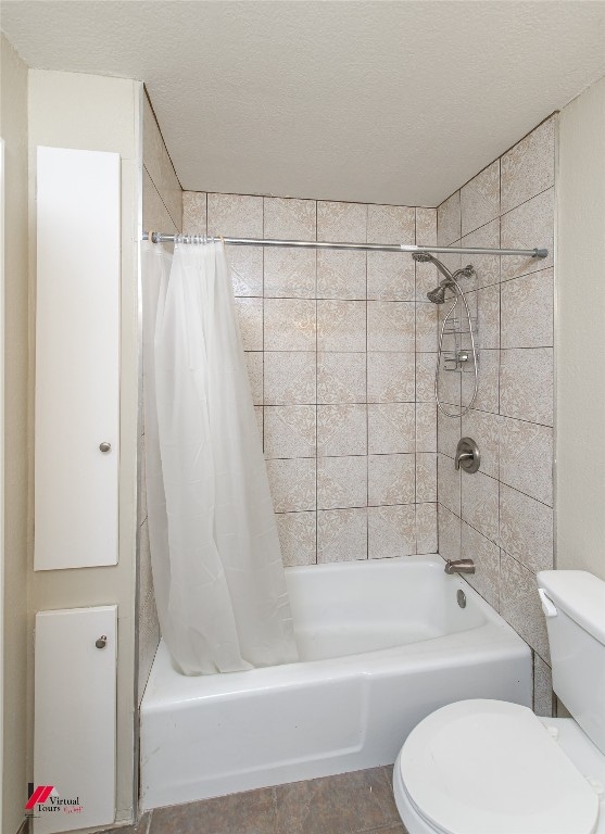 bathroom with shower / bath combo, toilet, a textured ceiling, and tile floors