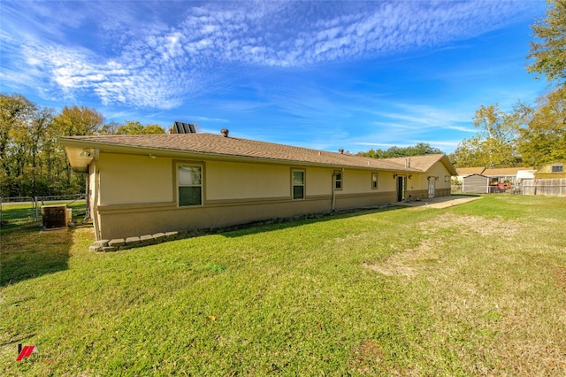 rear view of house featuring a yard