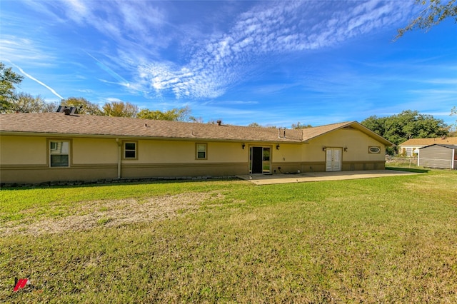 rear view of property featuring a patio and a yard