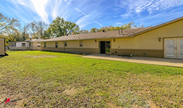 rear view of property with a yard, french doors, and a patio