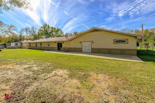 rear view of house featuring a yard and a patio