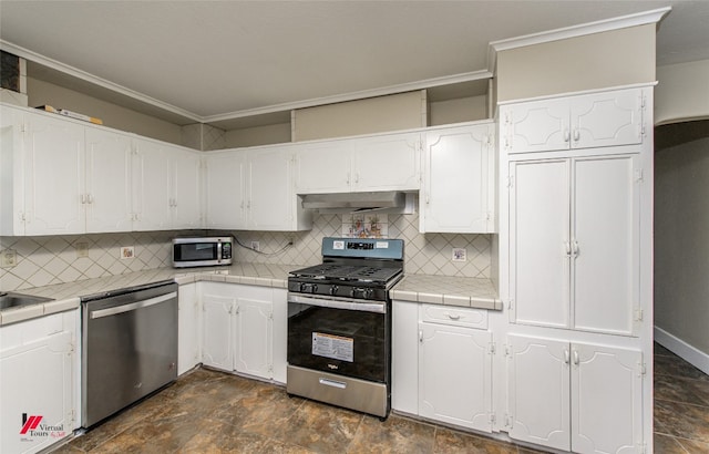 kitchen featuring white cabinets, dark tile floors, and appliances with stainless steel finishes