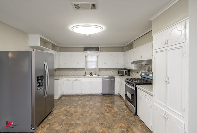 kitchen featuring white cabinets, tasteful backsplash, stainless steel appliances, and dark tile floors