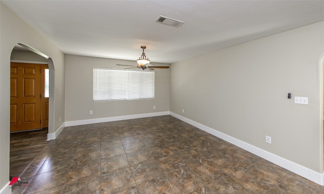 unfurnished room with dark tile floors and ceiling fan