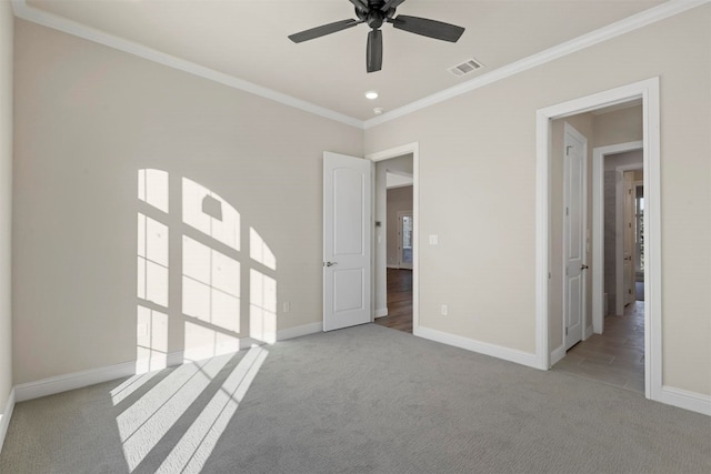 carpeted empty room featuring ceiling fan and ornamental molding