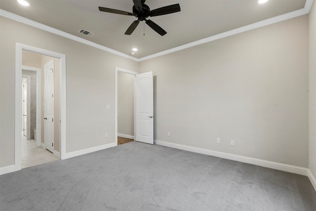 carpeted spare room featuring ceiling fan and crown molding