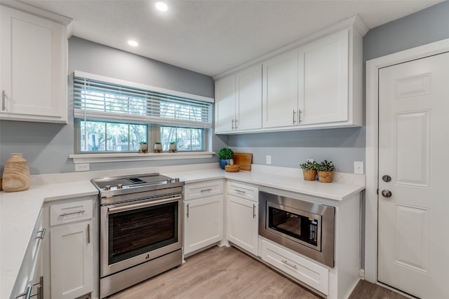 kitchen with white cabinets, stainless steel appliances, and light wood-type flooring