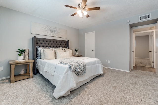 carpeted bedroom with a textured ceiling and ceiling fan